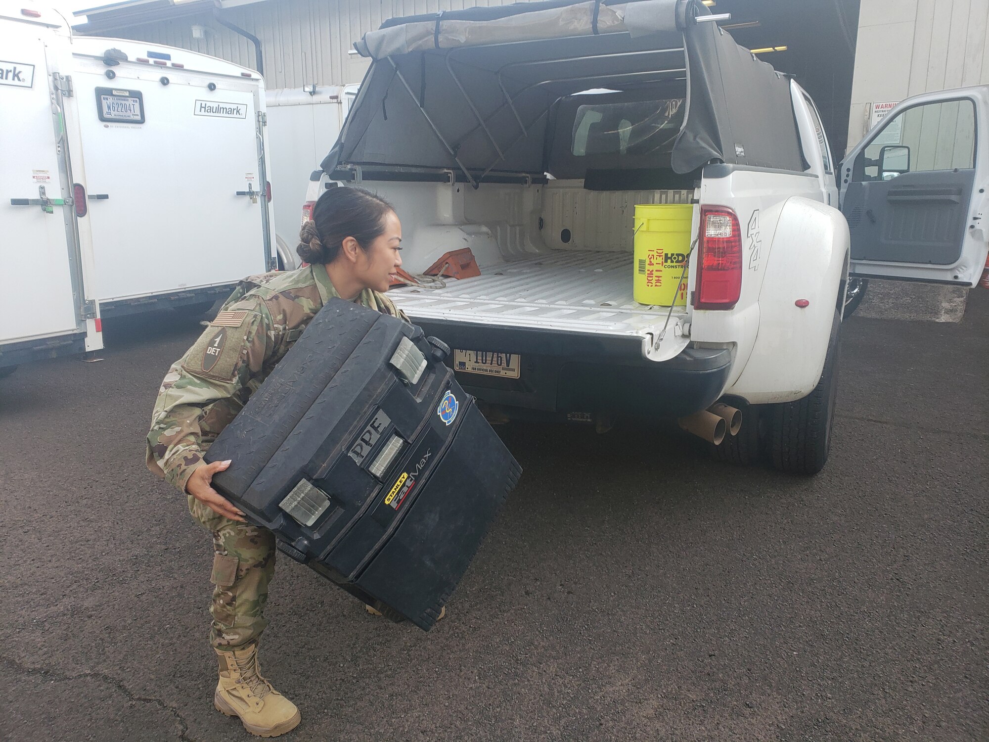 Airman 1st Class Jolene Chun loads the equipment to screen Hawaii National Guard Soldiers and Airmen preparing to assist in the COVID-19 pandemic March 30, 2020, Honolulu.