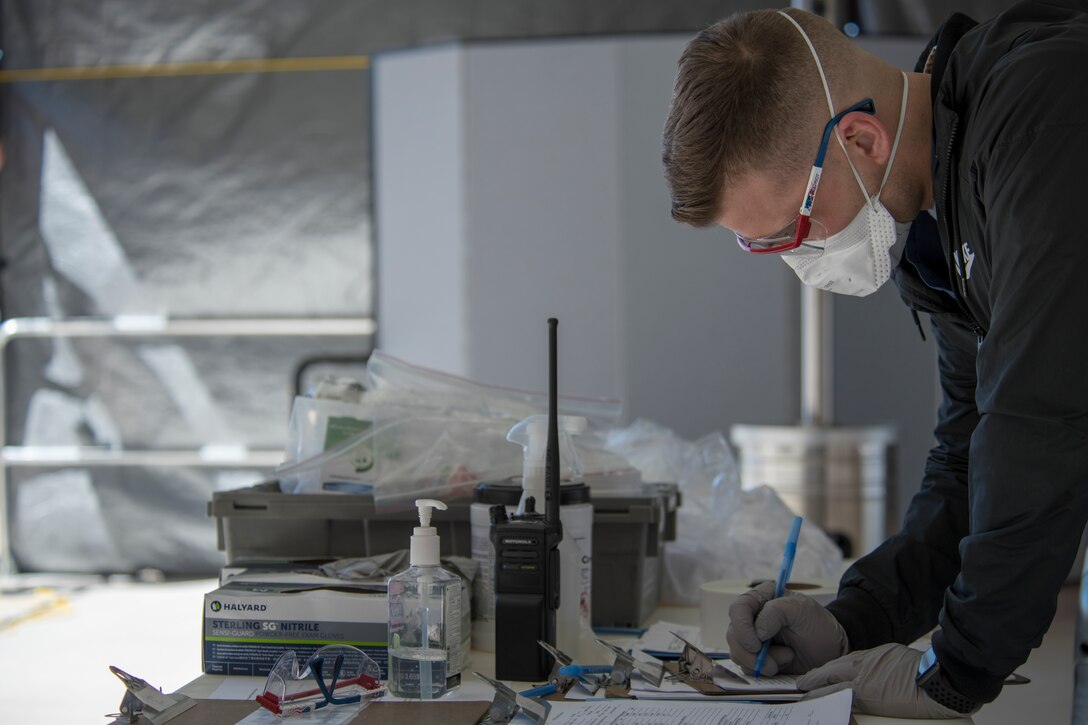 Airman 1st Class Josh Brinegar, 49th Medical Operations Squadron aerospace medical technician, fills out a patient screening form at the 49th Medical Group’s medical screening area on Holloman Air Force Base, N.M., March 20, 2020. A screening form holds information such as a patient’s recent travel, medical history and possible symptoms. Holloman medical professionals use this information to better evaluate a patient’s medical condition and provide adequate care, if needed. (U.S. Air Force photo by Senior Airman Collette Brooks)