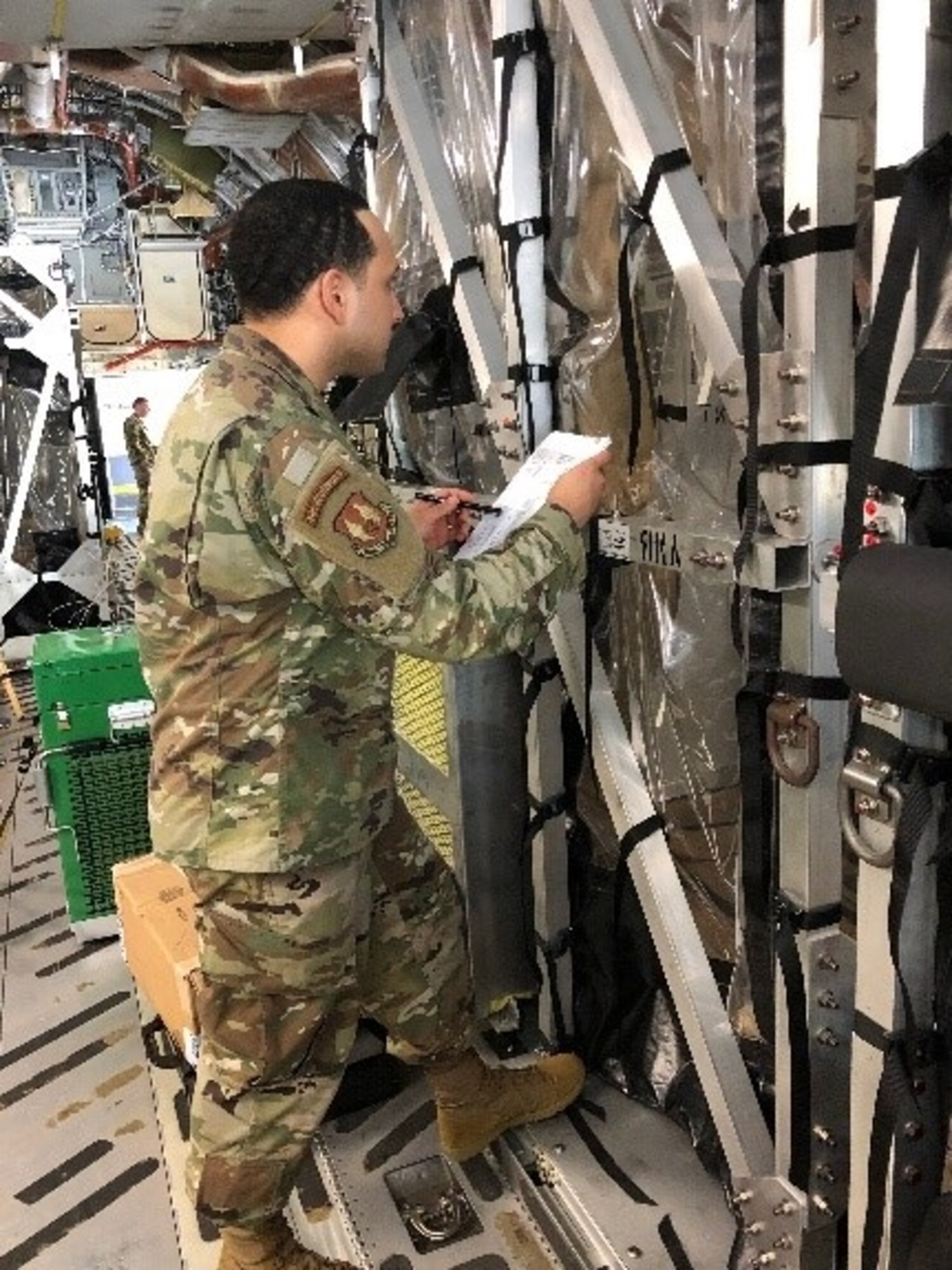 Tech. Sgt. Victor Kipping-Cordoba stands outside a Transport Isolation System (TIS) and provides instruction to an aeromedical evacuation member inside during a training session at Joint Base Charleston March 27, 2020. Kipping-Cordoba and others are training other medical professionals to use the TIS to safely transport patients with highly contagious diseases. (U.S. Air Force photo by Lt. Col. Elizabeth Schnaubelt)