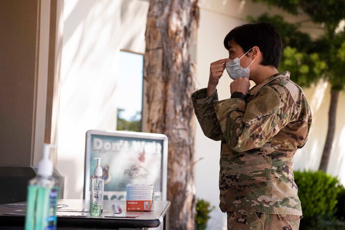 Maj. Aubrey Reid, 30th Medical Group nurse, demonstrates how to properly wear a procedural mask at the 30th MDG COVID-19 screening point March 30, 2020, at Vandenberg Air Force Base, Calif. Prior to entering and when exiting the 30th MDG, each individual is screened for COVID-19 symptoms, such as a cough or a fever. If a member presents any symptoms, they are provided with a mask to help prevent the spread of the virus.  (U.S. Air Force photo by Airman 1st Class Hanah Abercrombie)