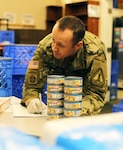 Master Sgt. Dustin McClure, Washington Army National Guard Recruiting and Retention Battalion, inventories canned food at the Issaquah Food Bank in Issaquah, Wash., April 2, 2020. Members of the Washington Air and Army National Guard are supporting food banks around the state during the COVID-19 pandemic.