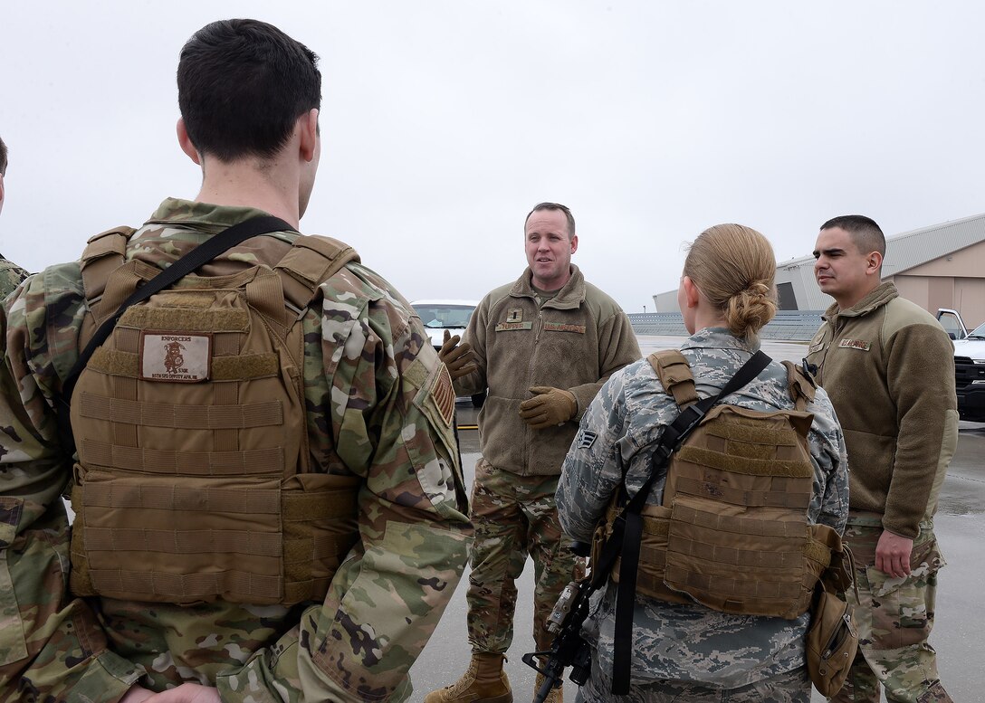 Three Airmen listening to an Air Force Captain  encouraging them during a wellness check.