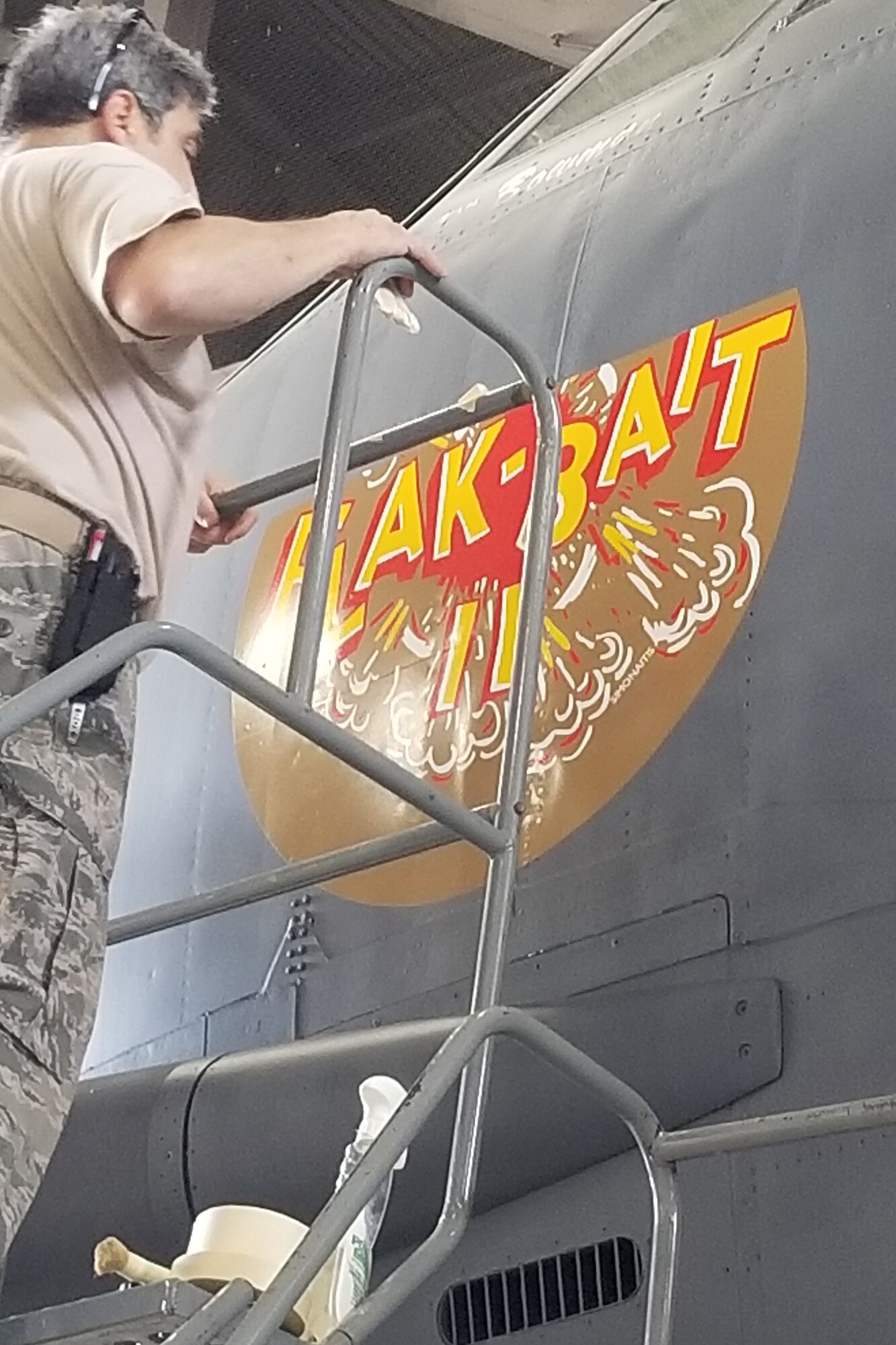 Photo of Airman putting on nose art.