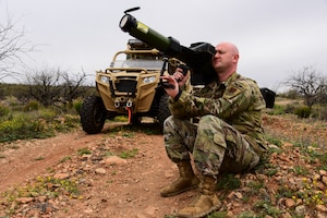 Tech. Sgt. points a missile-to-air cannon toward aircraft during a training