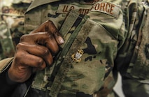 Master Sgt. Cary Ann Thomas, 628th Contracting Squadron contingency cell section chief, presents her Coast Guard chief recognition pin at Joint Base Charleston, S.C., March 31, 2020.