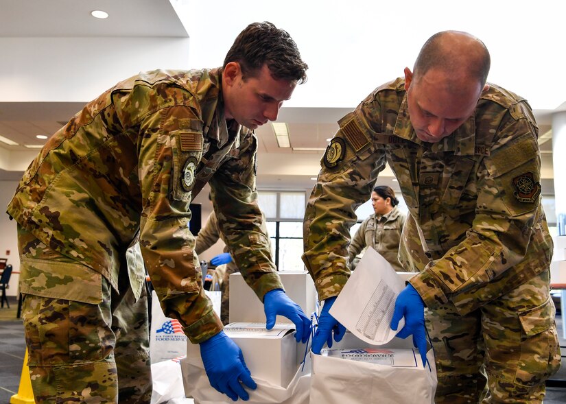 A photo of two Airmen inspected boxed lunches.
