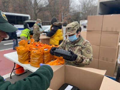 New York Army National Guard Spc. Thalio Hinajosa, assigned to Battery B, 1st Battalion, 258th Field Artillery, part of the 27th Infantry Brigade Combat Team, packs meals for distribution to the community at the Thomas Jefferson Recreation Center in New York City March 30, 2020. Hinajosa is one of more than 2,700 New York Guard members helping mitigate the COVID 19 pandemic.