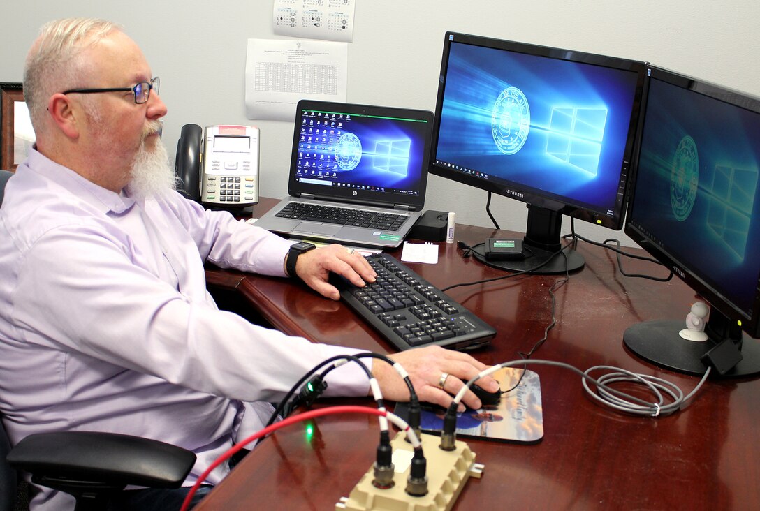 Chris Carr, an AEDC Instrumentation, Data and Controls engineer, demonstrates how the Cross-Domain Solution, or CDS, works Feb. 12, 2020, at Arnold Air Force Base, Tenn. The CDS interface was researched as a solution to allow plant operations systems outside of the plant control room to remain unclassified during classified test programs. As part of an AEDC Innovation Grant project, Carr and several AEDC team members worked together to determine whether plant control parameters could be normalized with the addition of a CDS. (U.S. Air Force photo by Deidre Moon) (This image has been altered by obscuring items for security purposes.)
