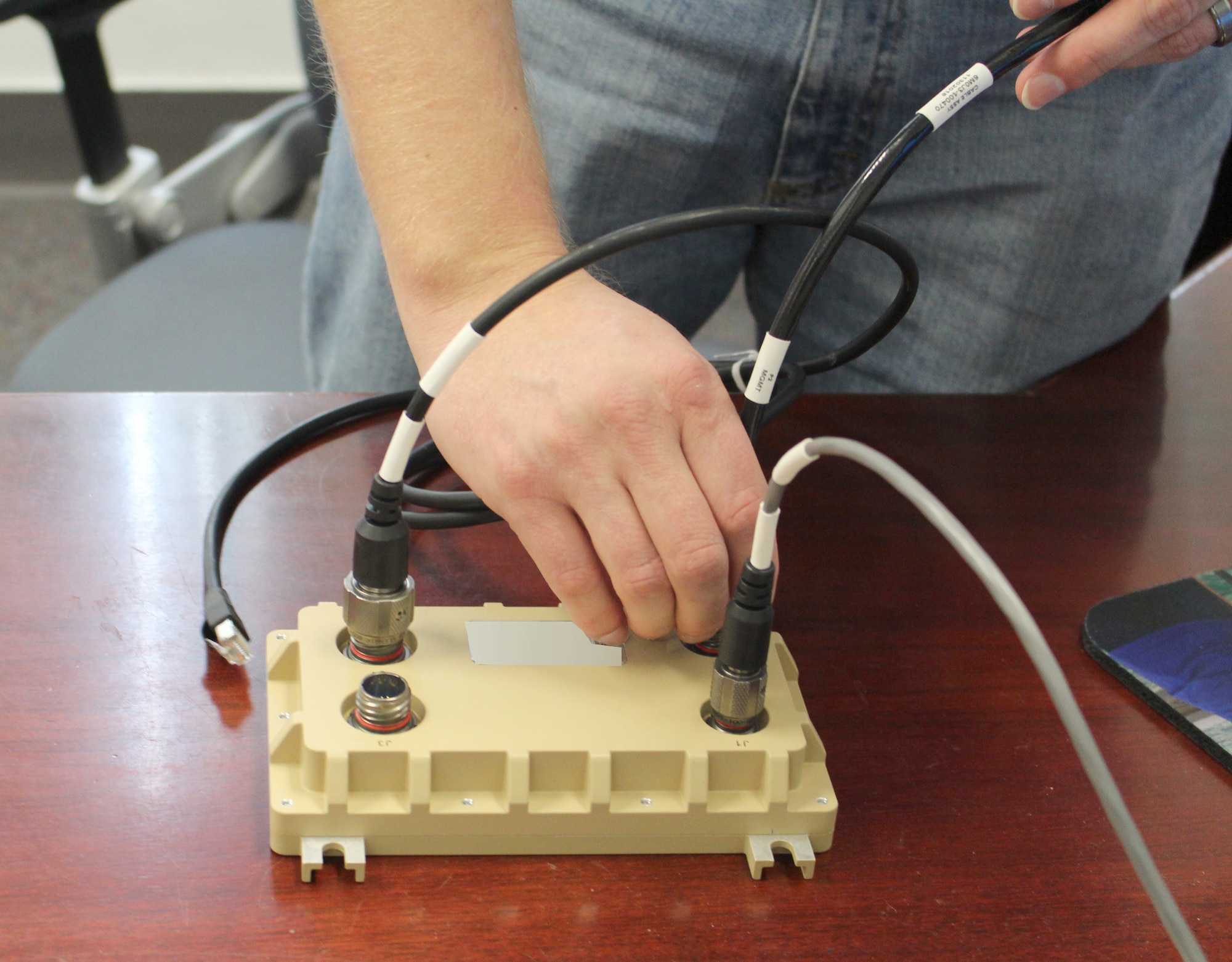 Scott Howard, an AEDC Instrumentation, Data and Controls engineer, sets up the Cross-Domain Solution hardware prior to connecting it to a desktop computer Feb. 12, 2020, at Arnold Air Force Base, Tenn. (U.S. Air Force photo by Deidre Moon) (This image has been altered by obscuring items for security purposes.)