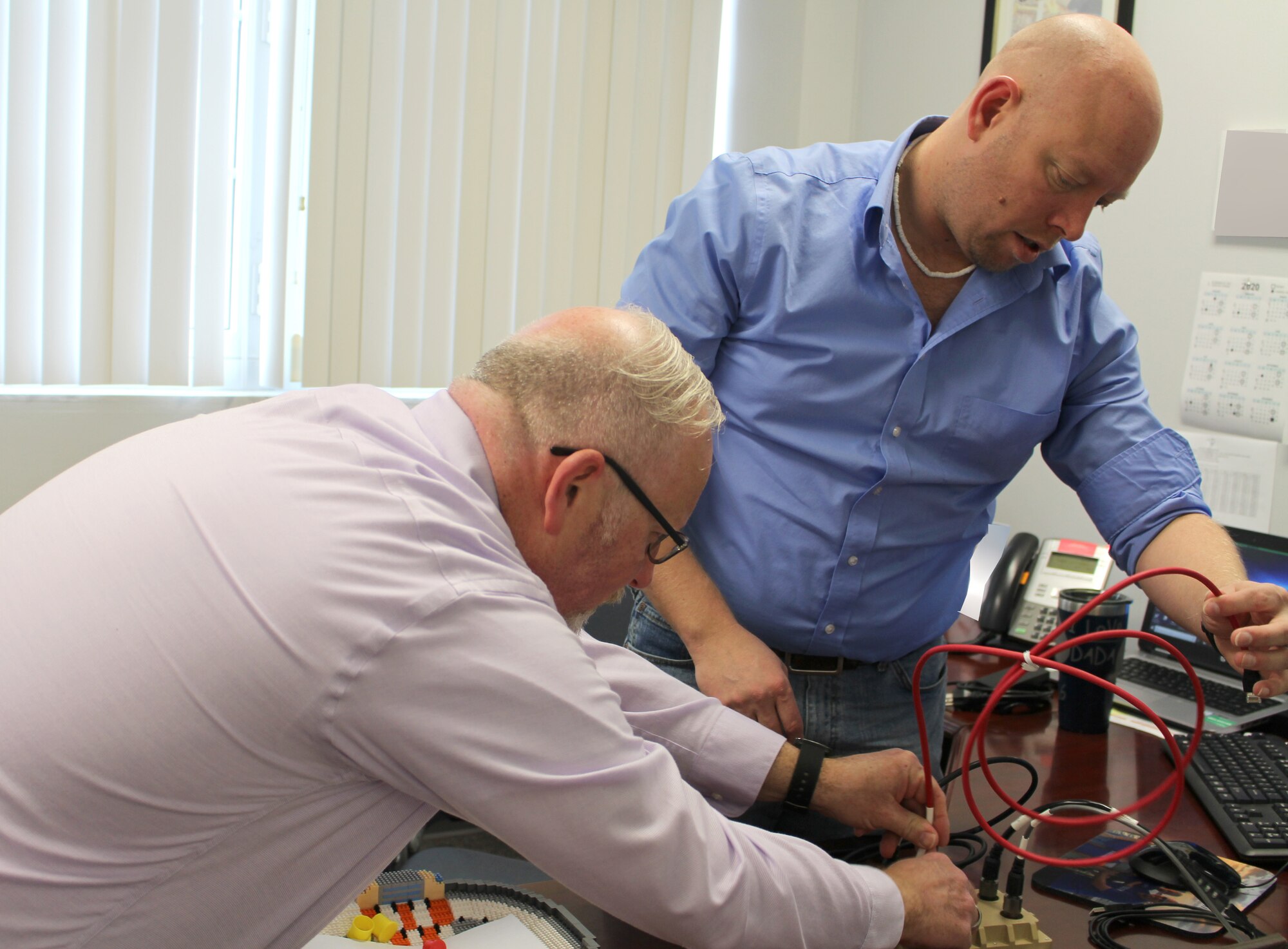 On Feb. 12, 2020, Chris Carr, left, and Scott Howard, Instrumentation, Data and Controls engineers at Arnold Air Force Base, Tenn., set up the Cross-Domain Solution hardware before connecting it to a desktop computer at Arnold to demonstrate how it is used. The CDS interface was researched as a solution to allow Plant Operations Systems outside of the Plant Control Room to remain unclassified during classified test programs. (U.S. Air Force photo by Deidre Moon) (This image has been altered by obscuring items for security purposes)