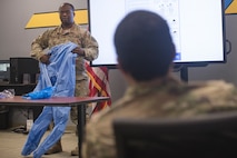 Staff Sgt. Myren Richardson, 437th Maintenance Group aircraft maintenance instructor, teaches students how to put on and remove personal protective equipment during a C-17 COVID-19 Decontamination Course at Joint Base Charleston, S.C., April 2, 2020. Members of the 437th MXG began implementation of the course March 28, 2020 to help ensure the safety of maintainers, aerial port personnel, aircrew and passengers while continuing support of Air Mobility Command’s rapid global mobility mission during the global pandemic.