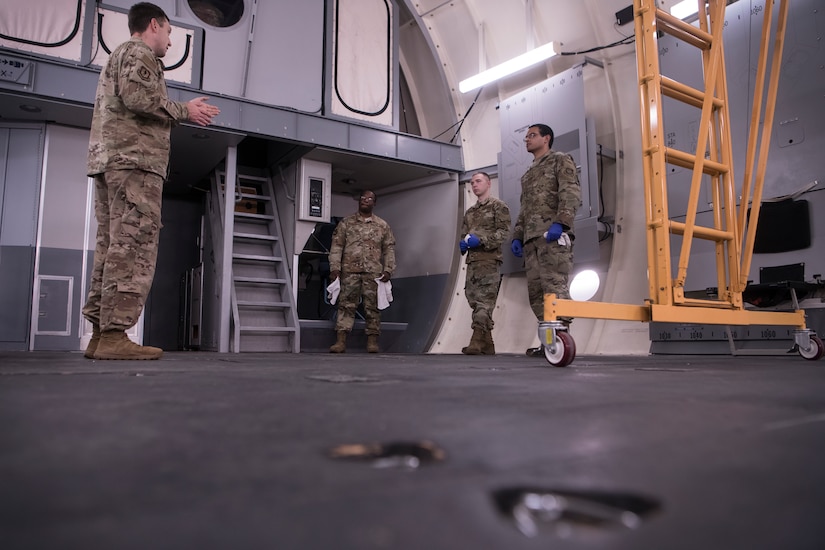 Master Sgt. Tyrell Hanley, left, 437th Maintenance Group development and instructor section chief, and Staff Sgt. Myren Richardson, center left, 437th MXG aircraft maintenance instructor, teach Senior Airman Evan Meyer, center right, and Staff Sgt. Michael Wells, both 437th Aircraft Maintenance Squadron flying crew chiefs, how to disinfect the interior of a C-17 Globemaster III using a mock C-17 aircraft trainer during a C-17 COVID-19 Decontamination Course at Joint Base Charleston, S.C., April 2, 2020. Members of the 437th MXG began implementation of the course March 28, 2020 to help ensure the safety of maintainers, aerial port personnel, aircrew and passengers while continuing support of Air Mobility Command’s rapid global mobility mission during the global pandemic.