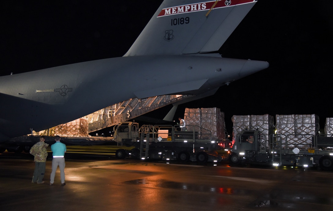 Pallets are unloaded from the rear of a C-17 aircraft.