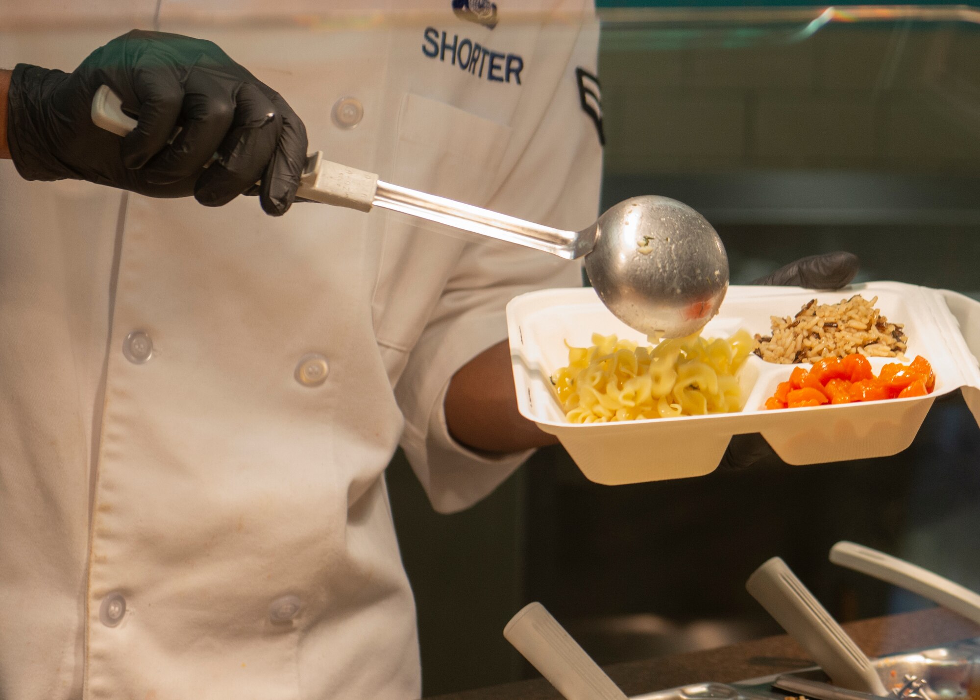 U.S. Air Force Airman 1st Class Robert Shorter, 673d Force Support Squadron food service apprentice, places food into a to-go box in the Iditarod Dining Facility on Joint Base Elmendorf-Richardson, Alaska, April 2, 2020. The dining facility suspended dining-in as a way to balance protective measures against COVID-19 while supporting military members to maintain mission readiness.