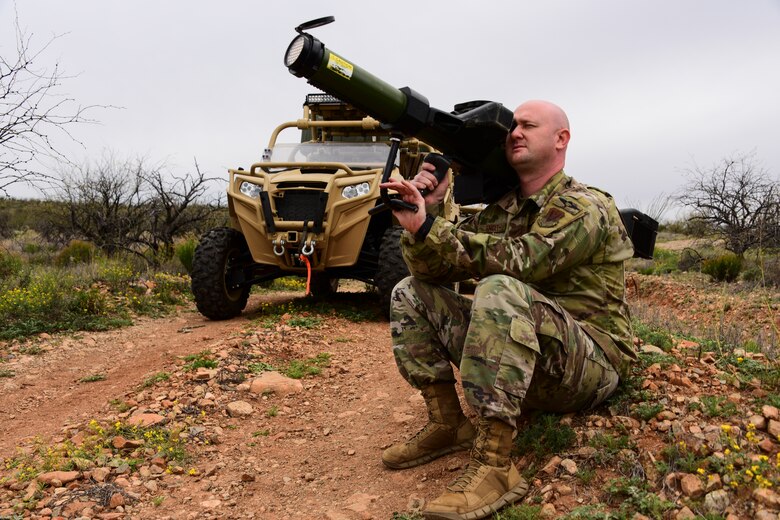 Tech. Sgt. points a missile-to-air cannon toward aircraft during a training