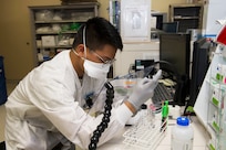 An airman performs lab testing
