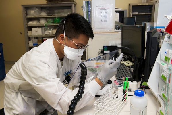 An airman performs lab testing