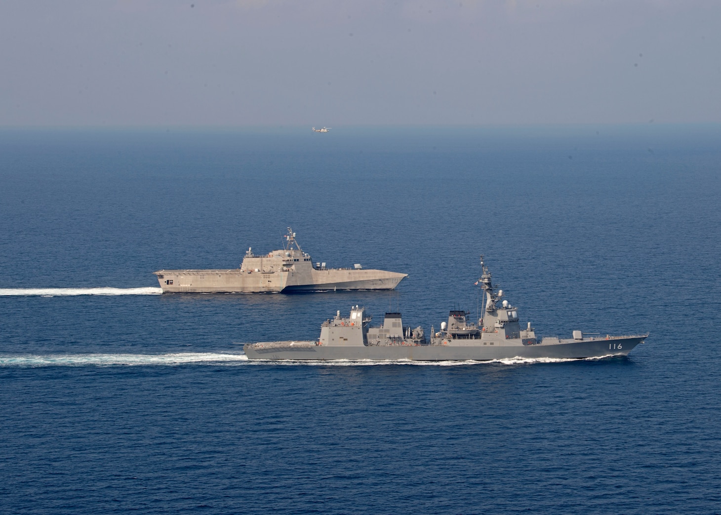 The Independence-variant littoral combat ship USS Gabrielle Giffords (LCS 10), top, sails alongside the Japan Maritime Self-Defense Force (JMSDF) Akizuki-class destroyer JS Teruzuki (DD 116) during a cooperative deployment, April 2, 2020.