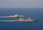 The Independence-variant littoral combat ship USS Gabrielle Giffords (LCS 10), top, sails alongside the Japan Maritime Self-Defense Force (JMSDF) Akizuki-class destroyer JS Teruzuki (DD 116) during a cooperative deployment, April 2, 2020.