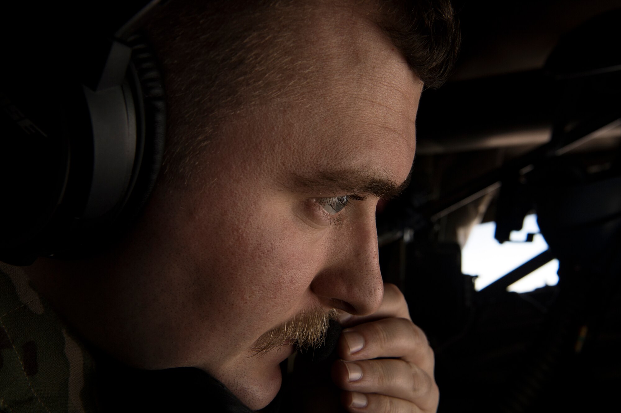 U.S. Air Force Airman 1st Class Paul Rietveld a 28th Expeditionary Air Refueling Squadron in-flight refueling specialist, talks with an F-16 Fighting Falcon pilot during an aerial refueling over Iraq, Feb. 6, 2020.
