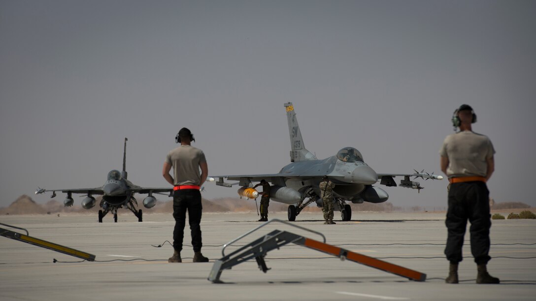 U.S. Air Force Airmen with the 380th Expeditionary Aircraft Maintenance Squadron wait for two U.S. Air Force F-16 “Viper” Fighting Falcons assigned to the 79th Expeditionary Fighter Squadron to taxi at an undisclosed location in the U.S. Central Command area of responsibility, Feb. 14, 2020.