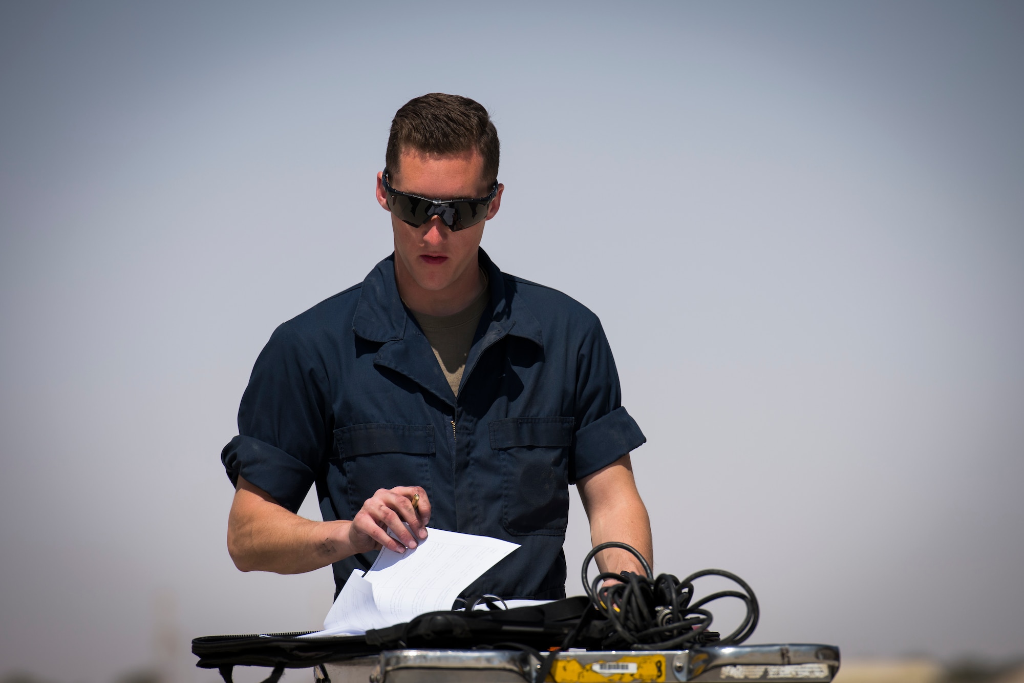U.S Air Force Airman 1st Class Lucas Haas, a crew chief with the 380th Expeditionary Aircraft Maintenance Squadron fills out maintenance logs at an undisclosed location in the U.S. Central Command area of responsibility, Feb. 14, 2020.