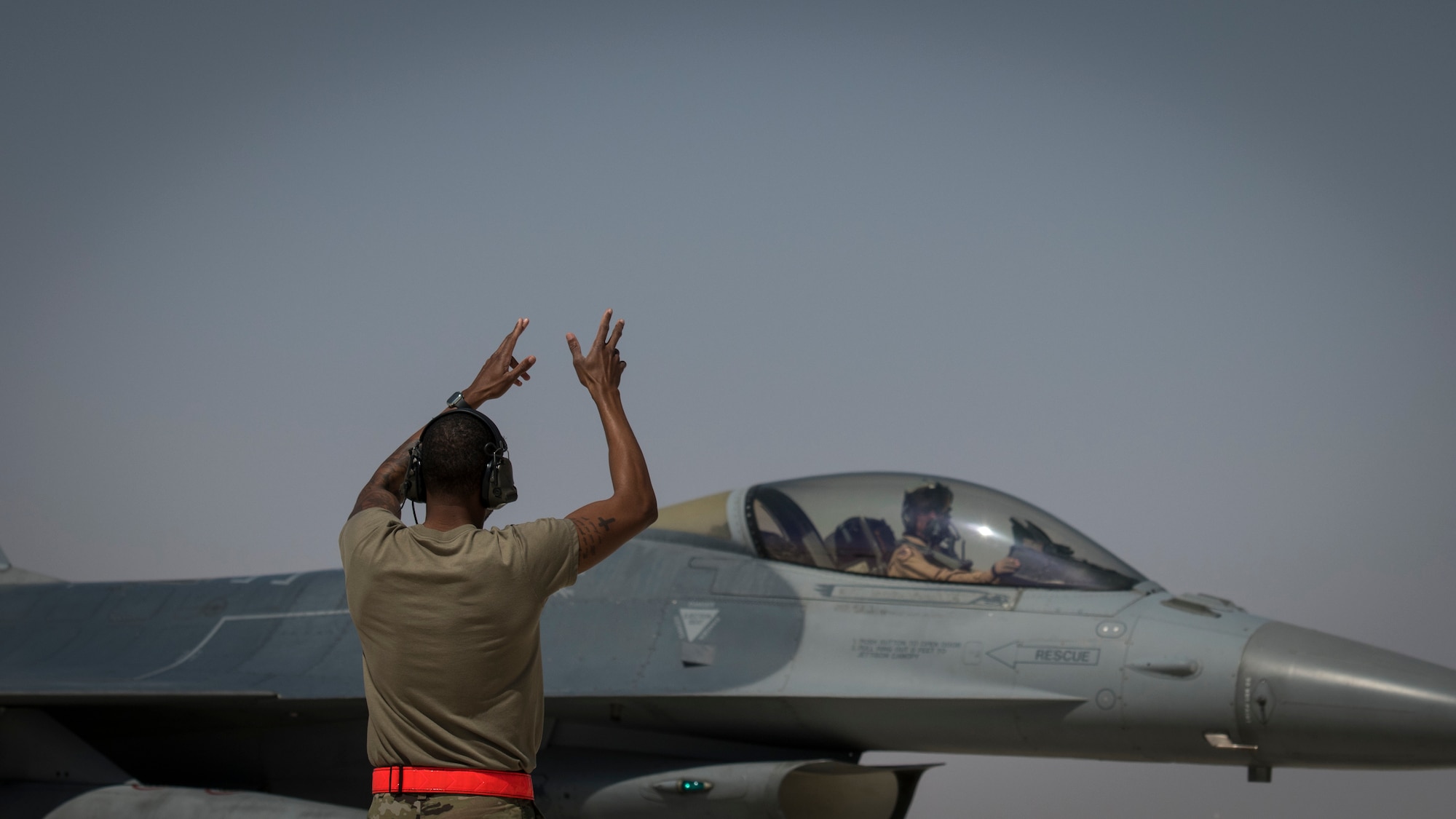 U.S Air Force Staff Sgt. Nathan Stokes, a crew chief with the 380th Expeditionary Aircraft Maintenance Squadron guides a U.S. Air Force F-16 “Viper” Fighting Falcon assigned to the 79th Expeditionary Fighter Squadron at an undisclosed location in the U.S. Central Command area of responsibility, Feb. 14, 2020.