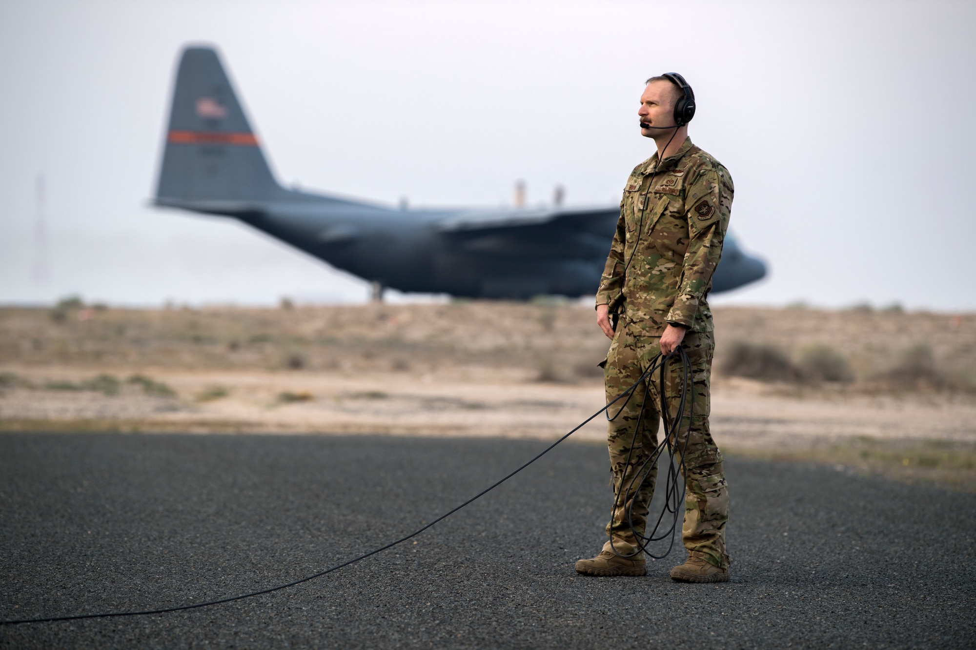 A U.S. Air Force loadmaster assigned to the 779th Expeditionary Airlift Squadron, watches engines start up from a C-130H Hercules at Ali Al Salem Air Base, Kuwait, Feb. 20, 2020.