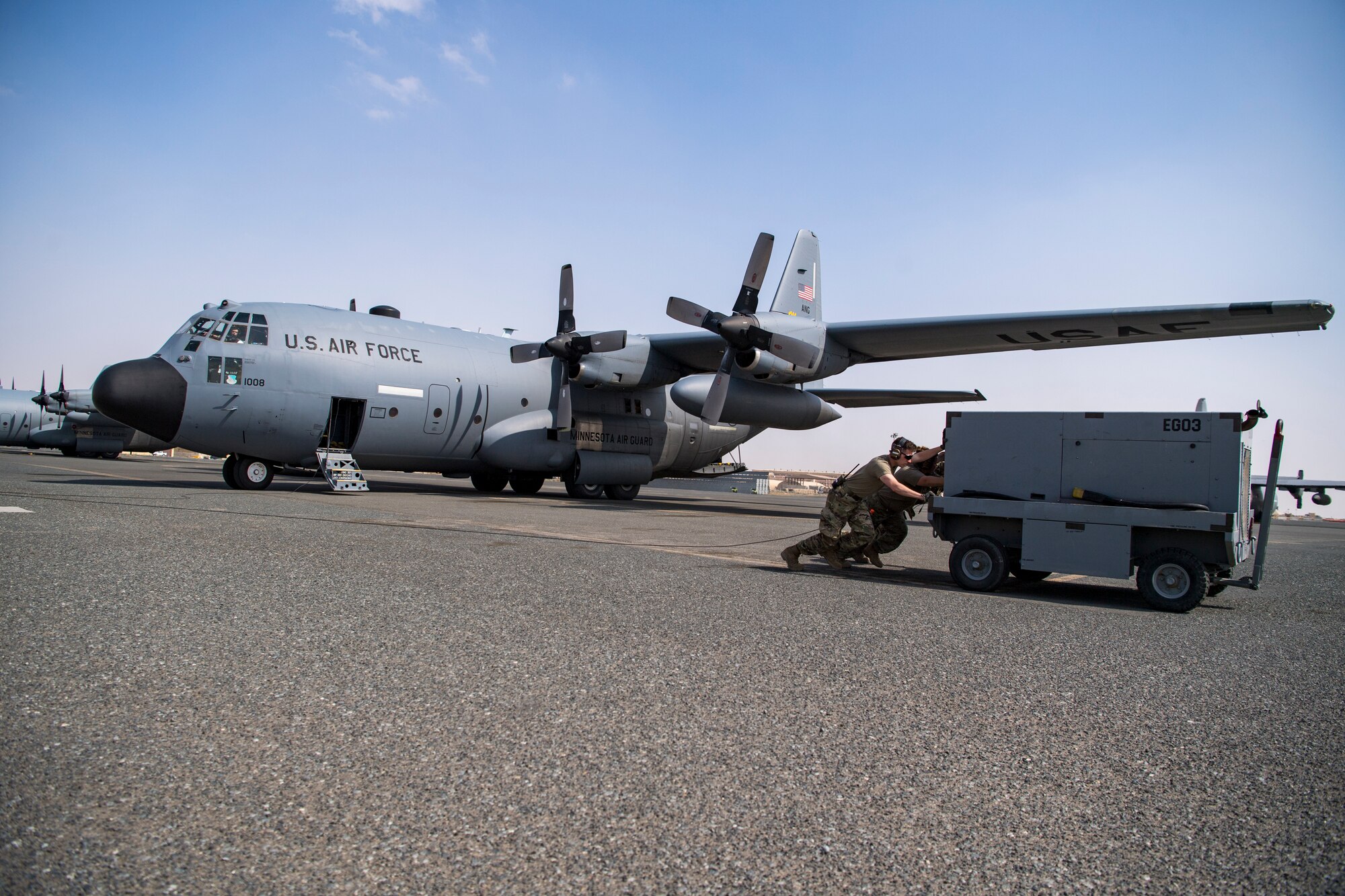A U.S. Air Force crew chiefs assigned to the 779th Expeditionary Airlift Squadron, push a power cart away from a C-130H Hercules at Ali Al Salem Air Base, Kuwait, Feb. 20, 2020.