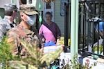 Staff Sgt. Travis Emery, front, and Airman 1st Class Soren Dietrichson, space operators for the California Air National Guard’s 216th Space Control Squadron, deliver food to residences in Orcutt, California, on April 2, 2020, as part of the Cal Guard’s COVID-19 humanitarian mission.