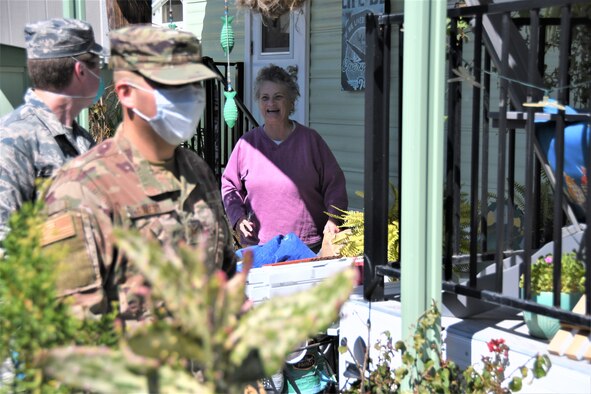 Staff Sgt. Travis Emery, front, and Airman 1st Class Soren Dietrichson, space operators for the California Air National Guard’s 216th Space Control Squadron, deliver food to residences in Orcutt, California, on April 2, 2020, as part of the Cal Guard’s COVID-19 humanitarian mission.