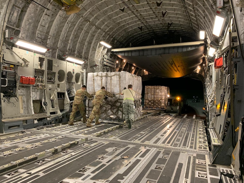 Photo of Airmen moving a pallet on an aircraft.