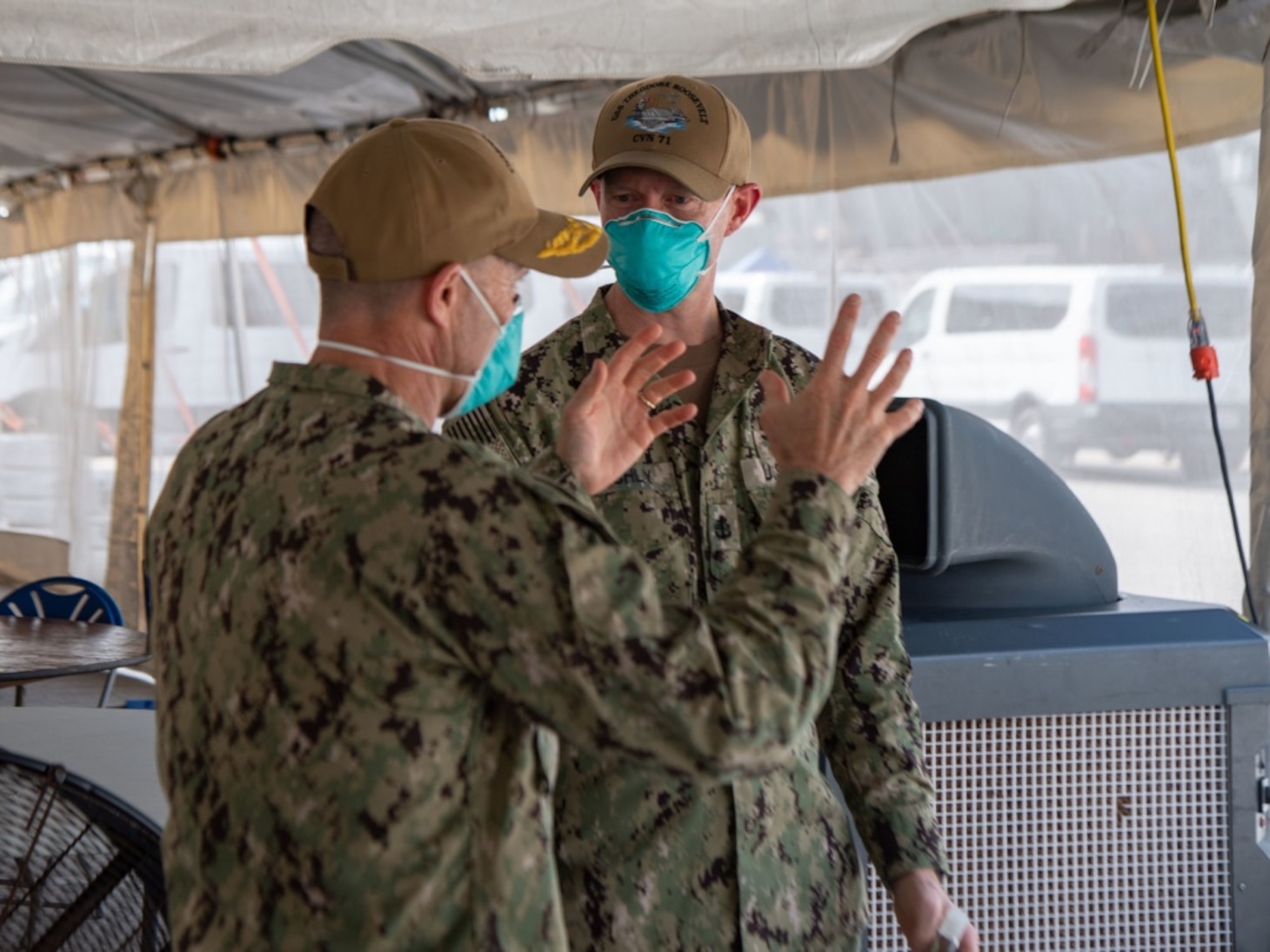 U.S. Navy Vice Adm. Bill Merz, commander, U.S. 7th Fleet, talks to Chief Mass Communication Specialist Christopher Blachly, from Ridgecrest, Calif., leading chief petty officer of the aircraft carrier USS Theodore Roosevelt's (CVN 71) media division April 5, 2020. Merz arrived in Guam to assess and support the ongoing COVID-19 recovery efforts for the crew of Theodore Roosevelt. Theodore Roosevelt is in Guam for a scheduled port visit for resupply and crew rest during their scheduled deployment to the Indo-Pacific. (