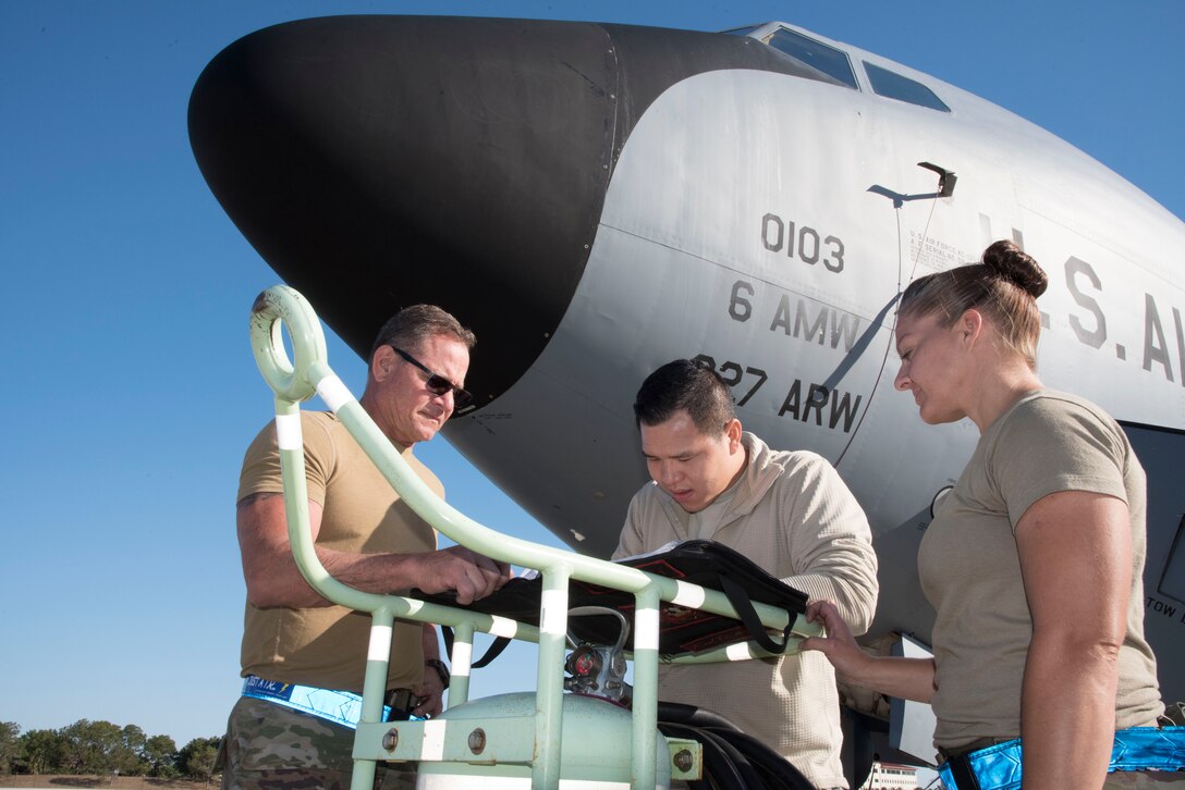 Staff Sgt. Tung Tran (center) a KC-135 aircraft maintainer with the 927th Aircraft Maintenance Squadron documents a maintenance issue while Master Sgt. Robert MacEachern and Tech. Sgt. Jackie Van Wagner look on April 2, 2020 at Mac Dill AFB, Fla. The reservists are supporting ongoing flying operations despite COVID-19 concerns so they can maintain the aircraft’s readiness to accomplish wartime missions that are vital for the nation. (U.S. Air Force Photo by Lt. Col. Lisa Ray)