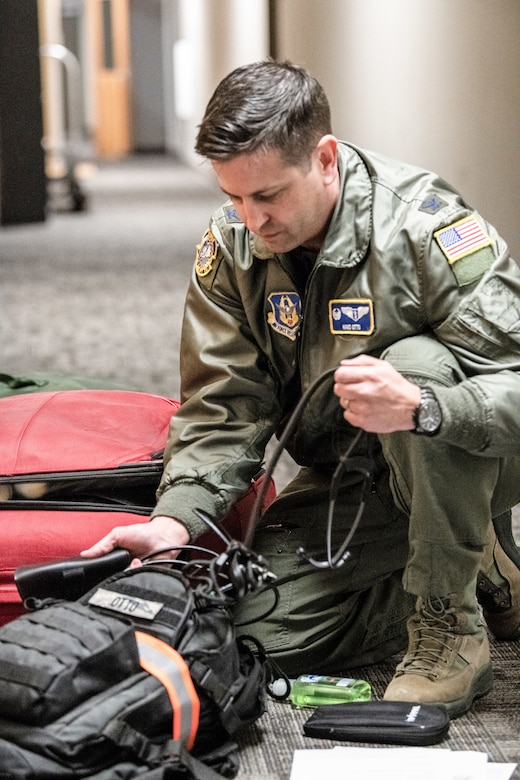 An airman checks his luggage for medical equipment.