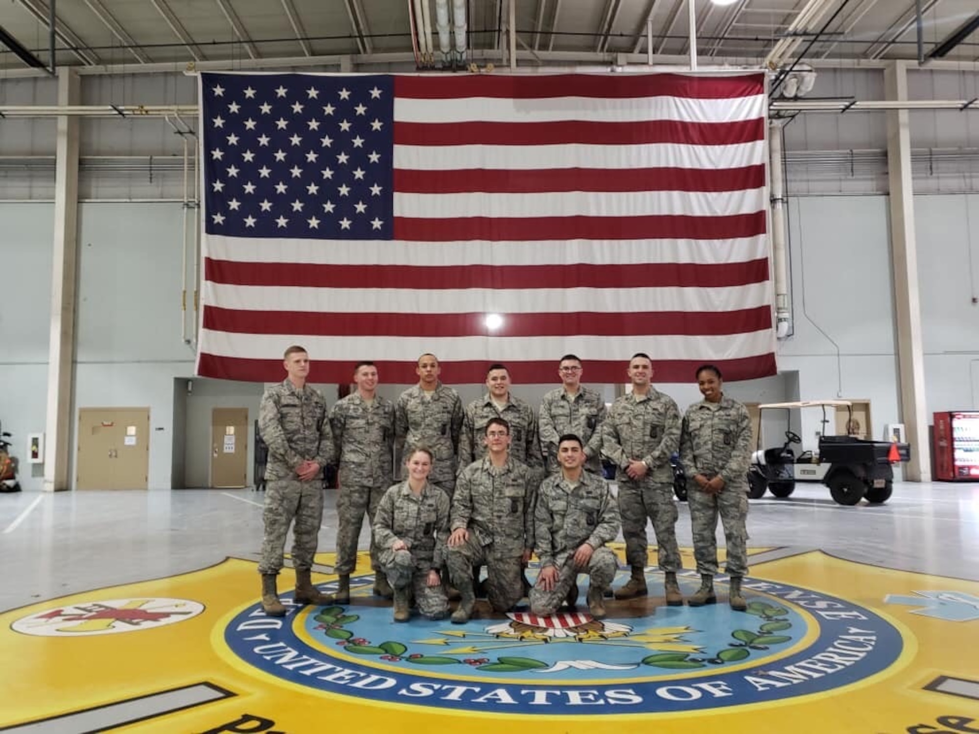 A large group photo with U.S. Air Force Airman 1st Class Kayla Jerido, 86th Civil Engineer Squadron fire protection apprentice, far right, posing with her classmates after graduating from the Louis F. Garland Department of Defense Fire Academy at Goodfellow Air Force Base, Texas, July 15, 2018.