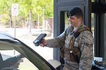 Senior Airman Caleb Sites, an entry controller assigned to the 628th Security Forces Squadron, scans the identification card of a Team Charleston member passing through the front gate at Joint Base Charleston, S.C., March 25, 2020. Security Forces maintains law and order on the installation, provides force protection, law enforcement, physical security and administrative support to JB Charleston Air Base and Weapons Station. Security Forces is taking protective measures, such as not touching ID cards and minimizing the amount of people that come in close contact with each other. Security Forces will continue to operate as normal. (U.S. Air Force photo by Airman Sara Jenkins)