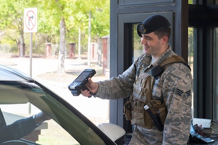 Senior Airman Caleb Sites, an entry controller assigned to the 628th Security Forces Squadron, scans the identification card of a Team Charleston member passing through the front gate at Joint Base Charleston, S.C., March 25, 2020. Security Forces maintains law and order on the installation, provides force protection, law enforcement, physical security and administrative support to JB Charleston Air Base and Weapons Station. Security Forces is taking protective measures, such as not touching ID cards and minimizing the amount of people that come in close contact with each other. Security Forces will continue to operate as normal. (U.S. Air Force photo by Airman Sara Jenkins)