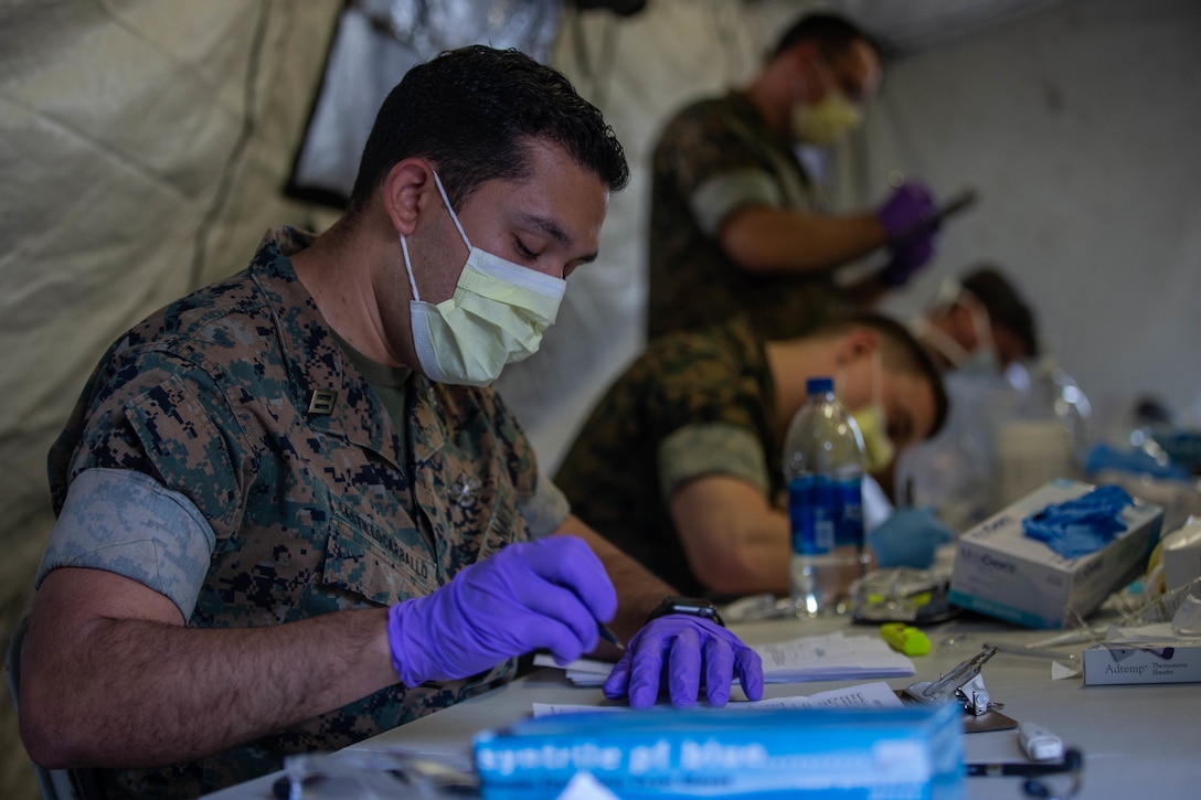 U.S. Navy Sailors with 2nd Medical Battalion, 2nd Marine Logistics Group pre-screen Marines with 2nd Light Armored Reconnaissance Battalion, 2nd Marine Division, on Marine Corps Air Station Cherry Point, N.C., March 30, 2020. II Marine Expeditionary Force is following the guidelines set by the Centers for Disease Control and Prevention and the Department of Health and Human Services to take the necessary precautions to protect redeploying service members and mitigate the spread of the coronavirus outbreak. (U.S. Marine Corps photo by Lance Cpl. Scott Jenkins)