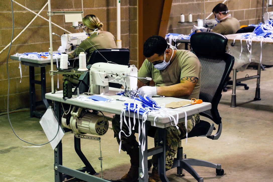 Soldiers use sewing machines to make surgical masks for patients.