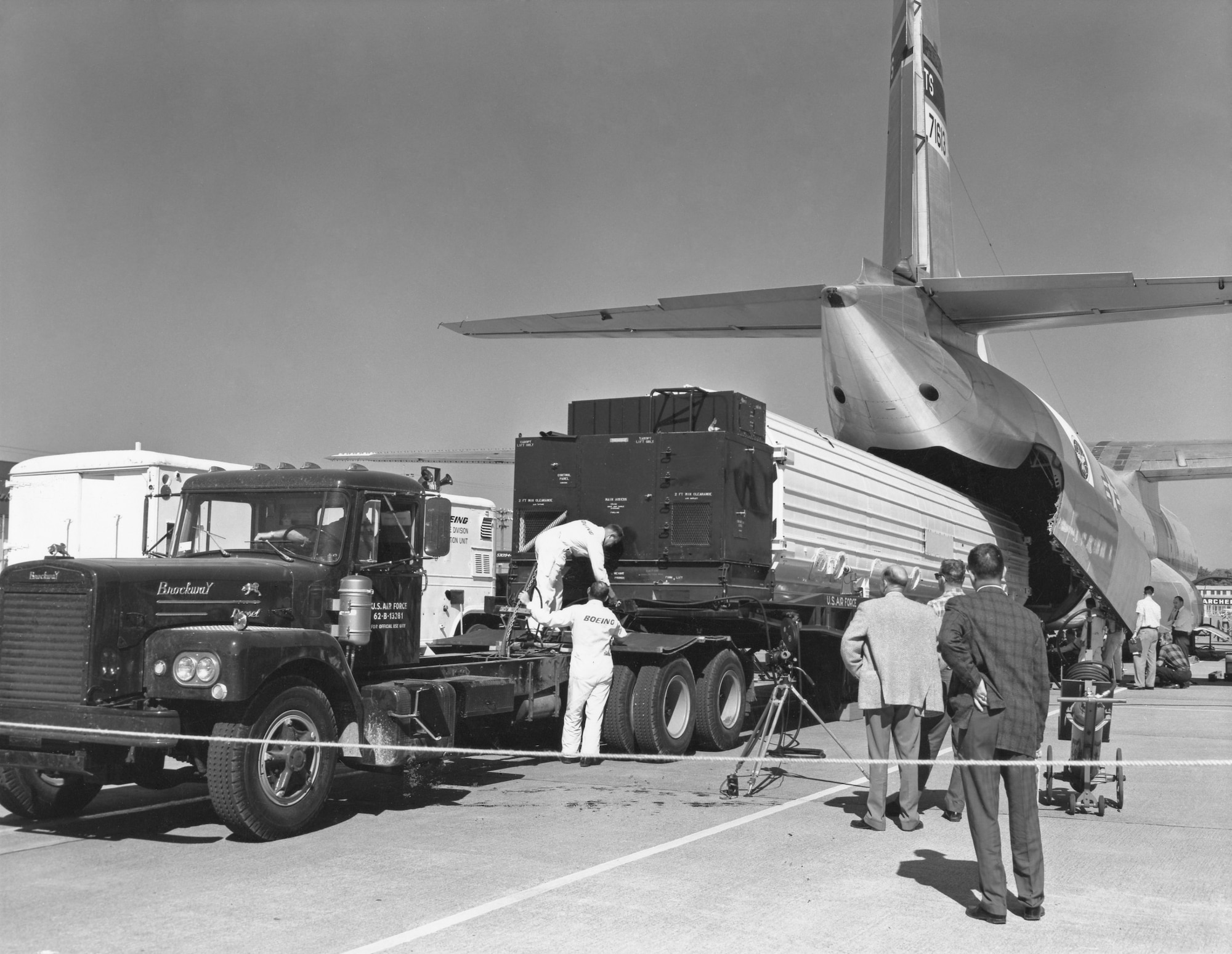 Personnel loading a Minuteman missile into the back of a C-133B aircraft.