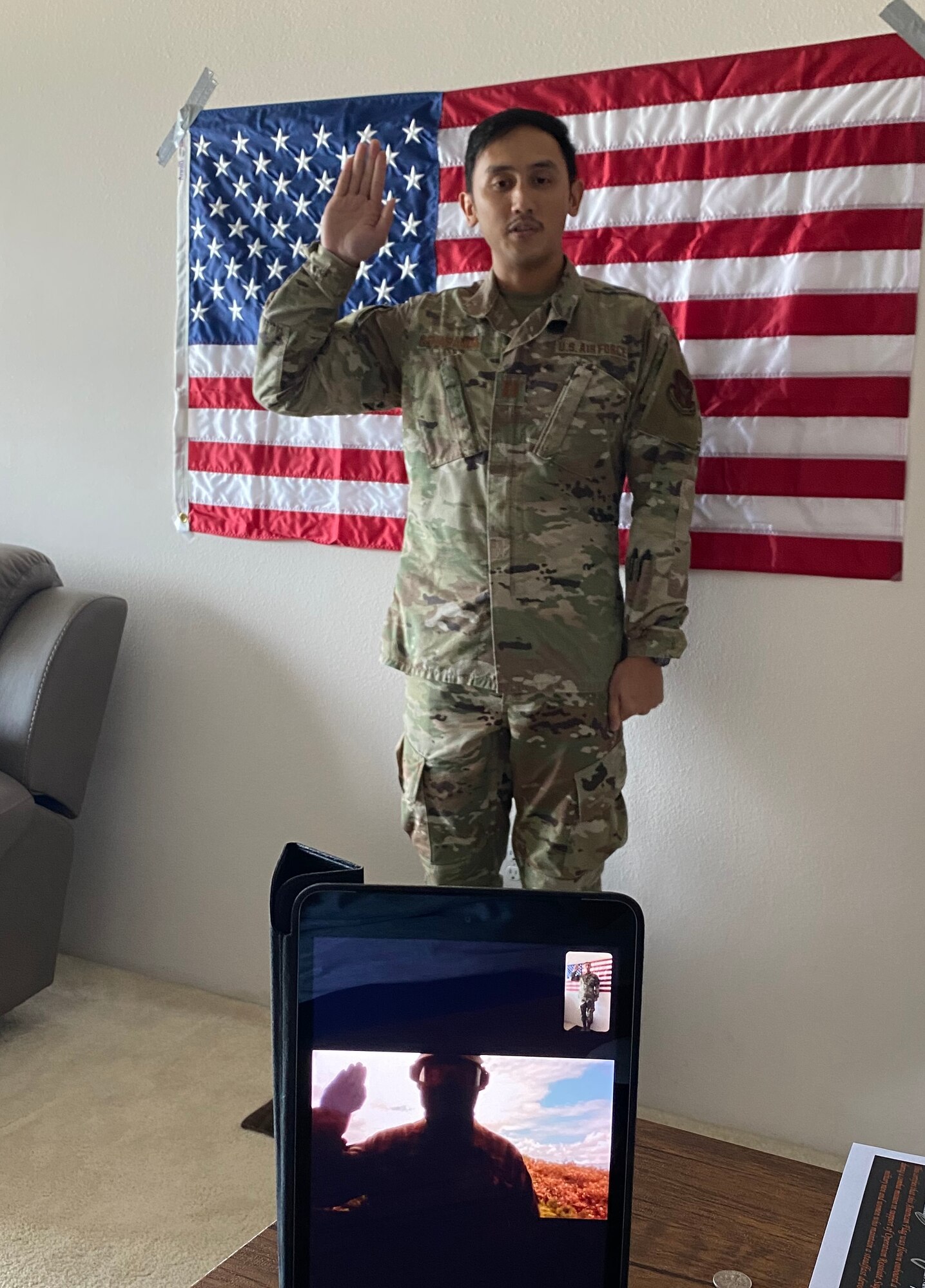A photo of U.S. Air Force Capt. John Penaranda, the 624th Civil Engineer Squadron readiness flight commander, administering the oath of enlistment via video teleconference during a virtual reenlistment for Tech. Sgt. Miguel Gil, a 624th Civil Engineer Squadron water and fuel systems maintenance craftsman, as part of the 624th Regional Support Group virtual unit training assembly April 4, 2020, from his home in Hawaii. Air Force Reserve Airmen in Hawaii and Guam continued mission readiness training during the first-ever 624th RSG virtual UTA, which was implemented to help keep Airmen safe during COVID-19 pandemic. (Courtesy Photo)