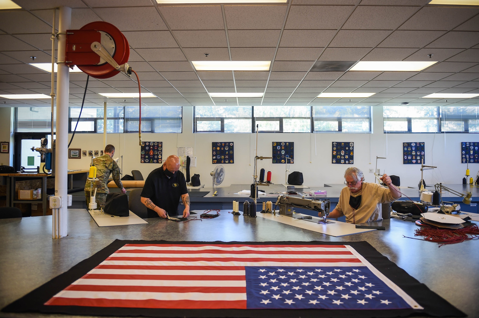 Cedrick del Castillo, second from left, and Gerald Eystad, right, 62nd Operations Support Squadron aircrew flight equipment fabrication shop technicians, work on making cloth face masks on Joint Base Lewis-McChord, Wash., April 6, 2020. The masks were distributed first to Airmen who come in contact with aircrews most frequently such as maintainers and AFE Airmen. (U.S. Air Force photo by Airman 1st Class Mikayla Heineck)