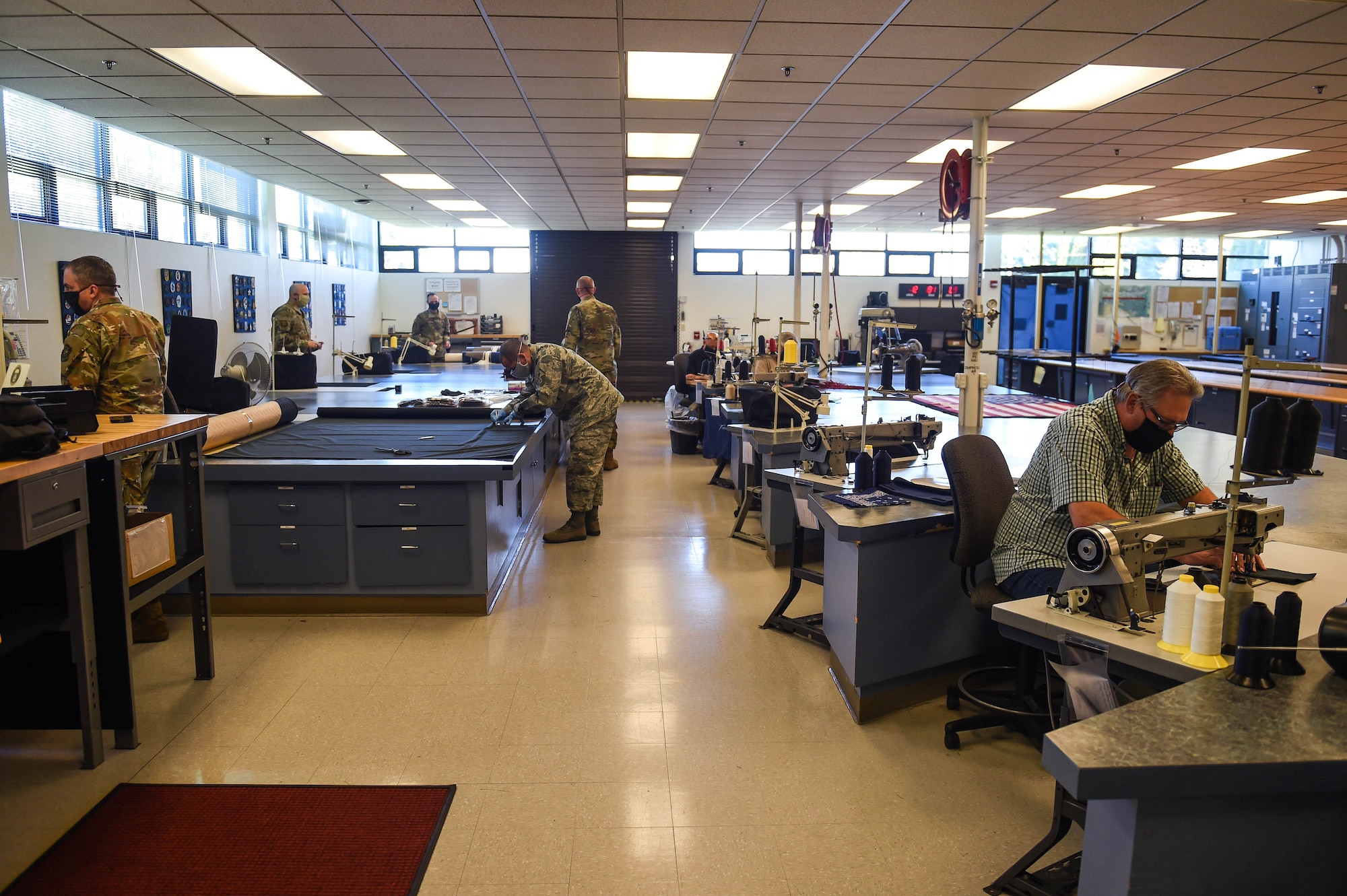 Members of the 62nd Operations Squadron aircrew flight equipment section, along with leaders from other Team McChord units, work to produce cloth face masks for mission-essential personnel at the AFE fabrication shop on Joint Base Lewis-McChord, Wash., April 6, 2020. The Center for Disease Control (CDC) advises the use of simple cloth face coverings to slow the spread of COVID-19. (U.S. Air Force photo by Airman 1st Class Mikayla Heineck)