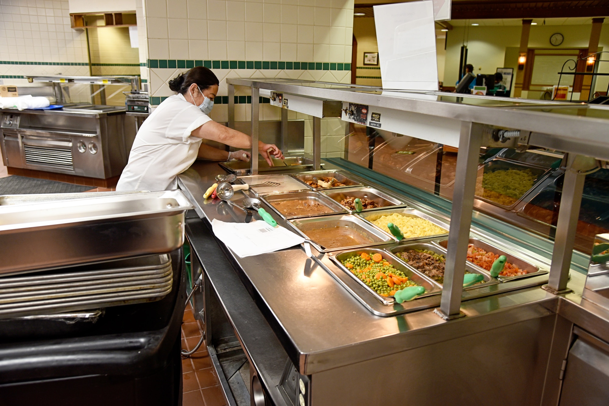 Yong McComb, the lead senior cook at the Vanwey Dining Facility, checks the food on the facility's reopening April 5, 2020.