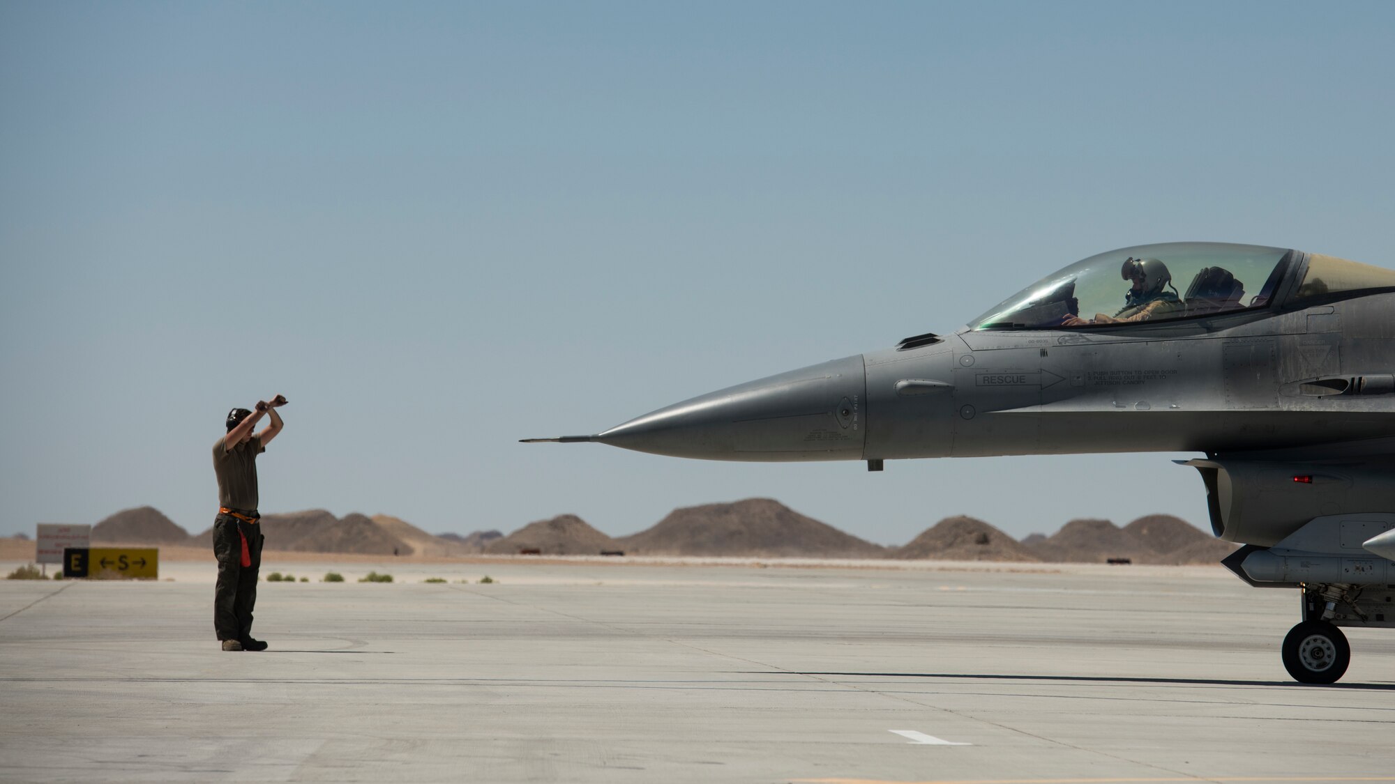 A U.S. Air Force crew chief with the 380th Expeditionary Aircraft Maintenance Squadron marshals U.S. Air Force Capt. Nomad D’Agostino, an F-16 “Viper” Fighting Falcon pilot with the 79th Expeditionary Fighter Squadron, at an undisclosed location in the U.S. Central Command area of responsibility, Feb. 23, 2020.