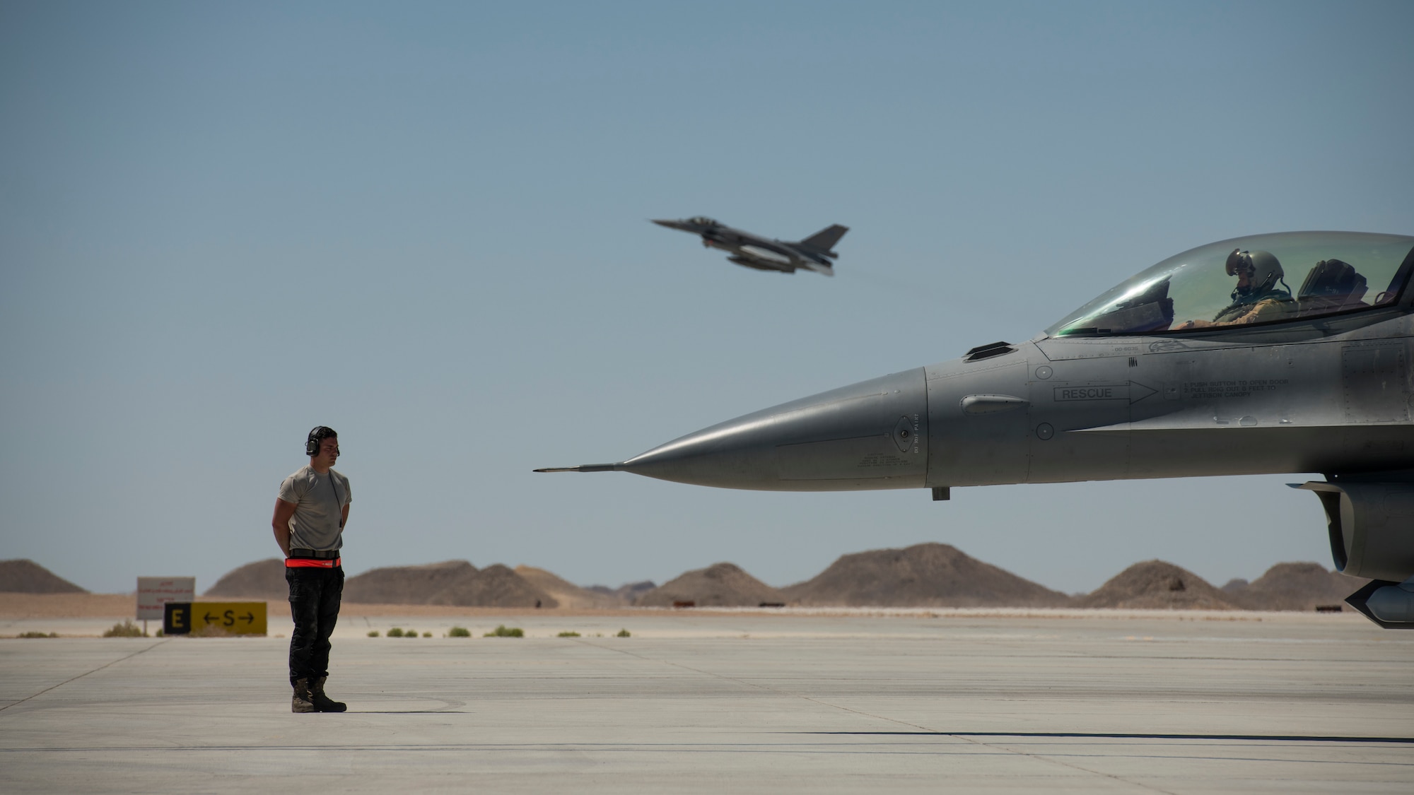 A U.S. Air Force crew chief with the 380th Expeditionary Aircraft Maintenance Squadron prepares to marshal U.S. Air Force Capt. Nomad D’Agostino, an F-16 “Viper” Fighting Falcon pilot with the 79th Expeditionary Fighter Squadron, at an undisclosed location in the U.S. Central Command area of responsibility, Feb. 23, 2020.