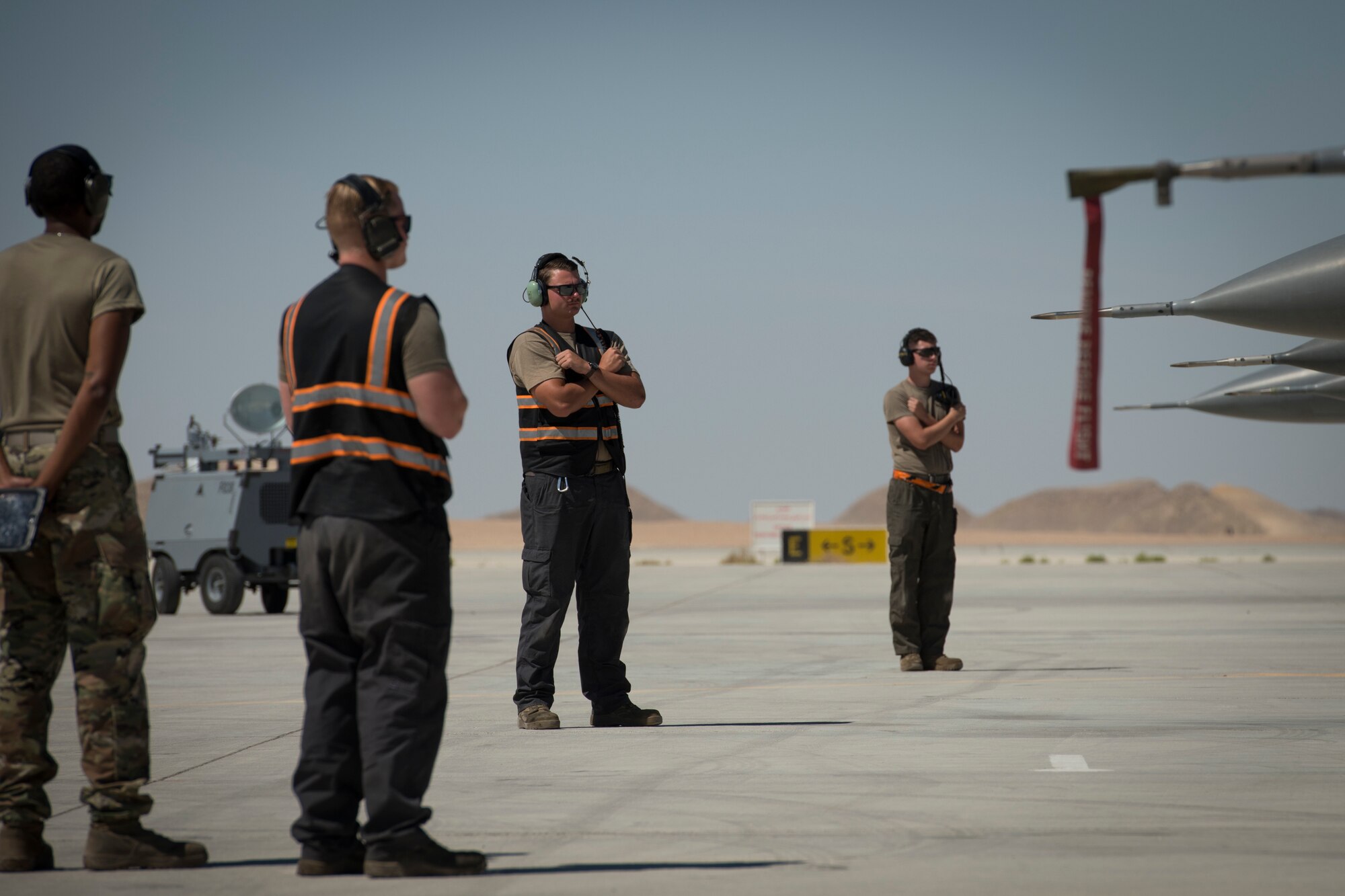 U.S Air Force Senior Airman Steven Kuethe, center, a crew chief with the 380th Expeditionary Aircraft Maintenance Squadron, waits to marshal a U.S. Air Force F-16 “Viper” Fighting Falcon assigned to the 79th Expeditionary Fighter Squadron at an undisclosed location in the U.S. Central Command area of responsibility, Feb. 24, 2020.
