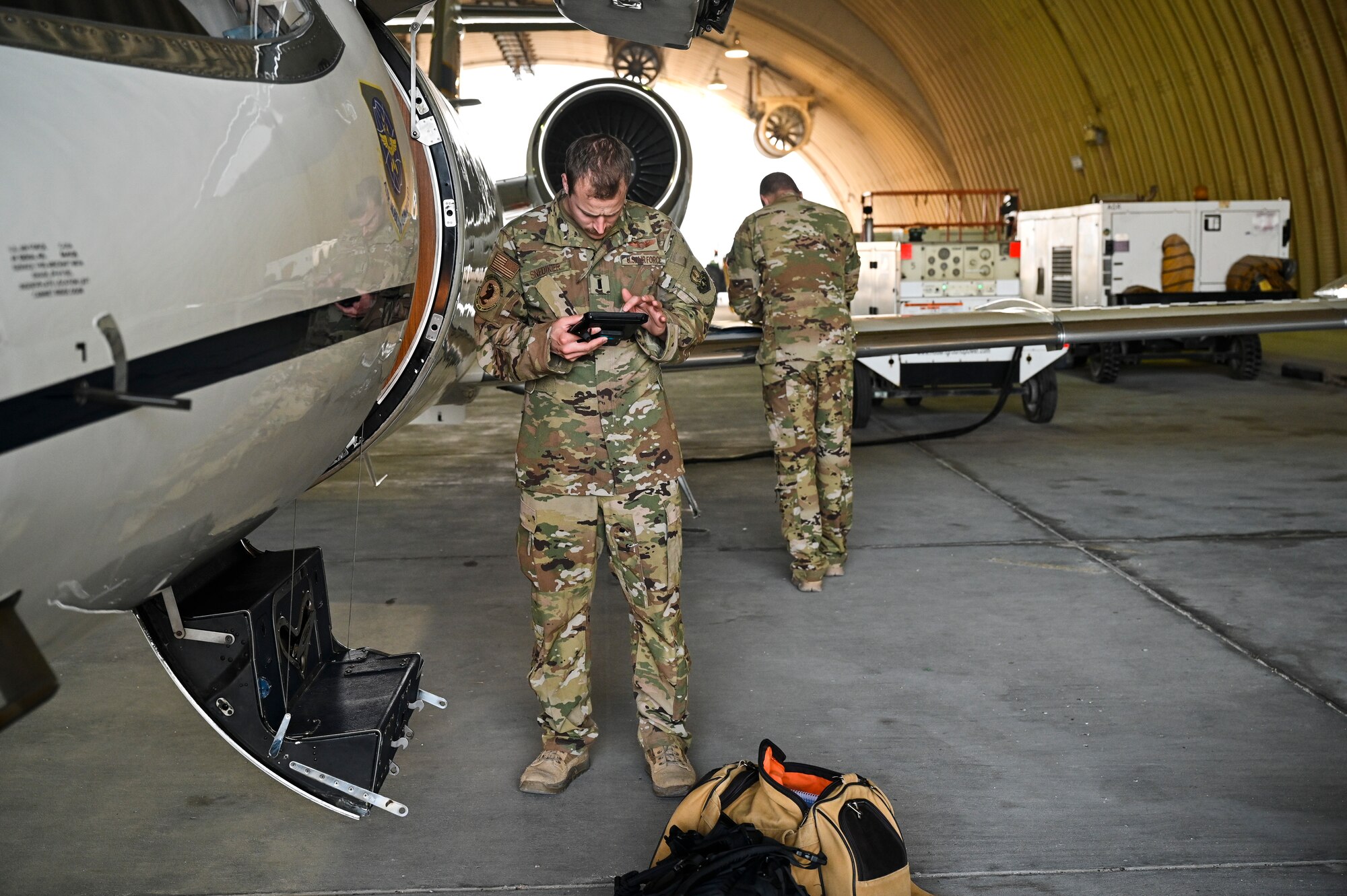 U.S. Air Force 1st Lt. Donald Snediker, left, and U.S. Air Force Capt. Greg Ihlenburg, pilots with the 746th Expeditionary Airlift Squadron deployed to Al Udeid Air Base, Qatar, prepare for a C-21 flight at AUAB, Feb. 24, 2020.