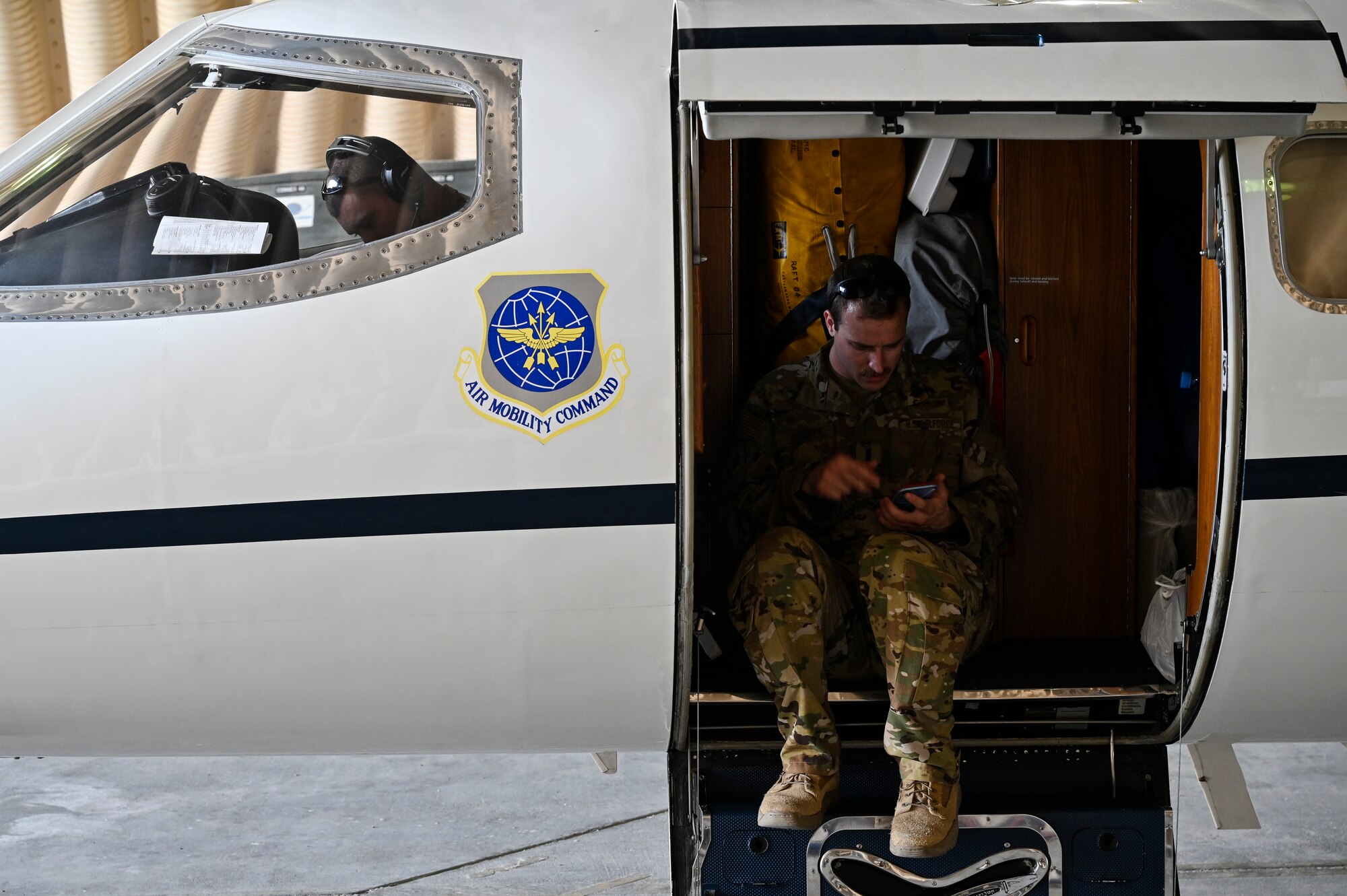 U.S. Air Force 1st Lt. Donald Snediker, right, and U.S. Air Force Capt. Greg Ihlenburg, pilots with the 746th Expeditionary Airlift Squadron deployed to Al Udeid Air Base, Qatar, prepare for a C-21 flight at AUAB, Feb. 24, 2020.